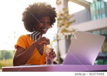 Happy beautiful young black woman using laptop in cafe 92275088