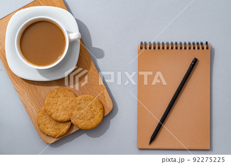 Cup of coffee with notebook on gray background top view Cup of coffee with notebook on gray background top view 92275225