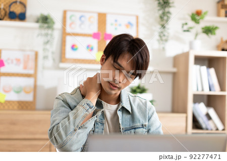 Asian man have a neck and sholuder pain during work at home office. Stressed on neck muscle problem after overworked. Office syndrome concept 92277471