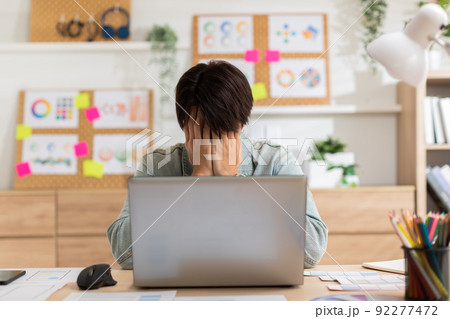 Stressed Asian man suffering from a strong migraine squeezing his head. Serious man have a headache with problem of him work. eye pain problem 92277472