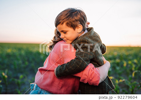 Loving smiling son hugs mom tightly. Tender family scene. Cute 3 year old ukrainian kid with mother 92279604