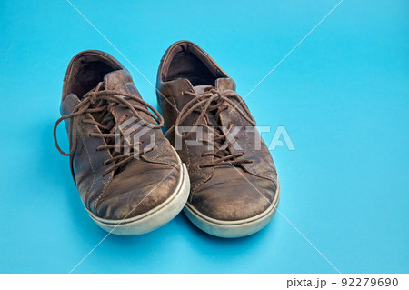 Beautifully aged vintage brown leather boots isolated on blue background with copy space 92279690