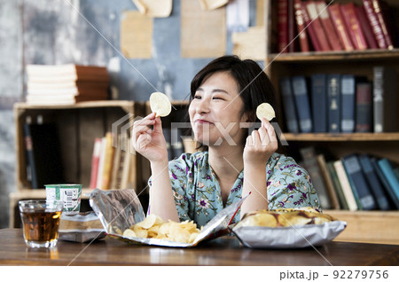 ポテトチップスを食べる女性 92279756
