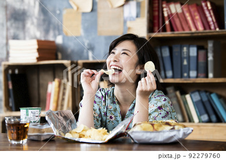 ポテトチップスを食べる女性 92279760