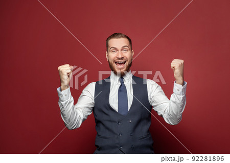 Excited businessman laughing on red banner background portrait.  92281896