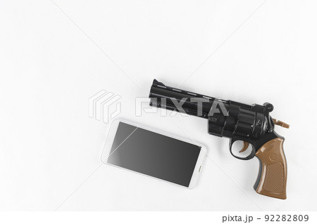 玩具の銃と、スマートフォン。犯罪予告のイメージ 92282809