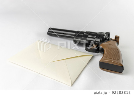 玩具の銃と、手紙の封筒。犯罪予告のイメージ 玩具の銃と、手紙の封筒。犯罪予告のイメージ 92282812