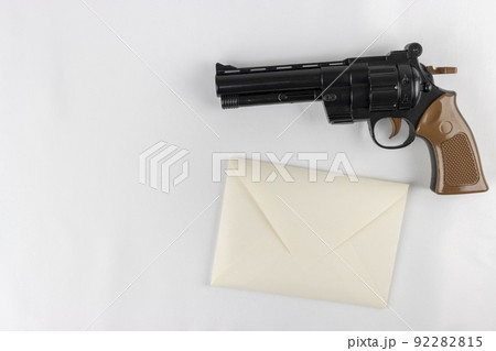 玩具の銃と、手紙の封筒。犯罪予告のイメージ 玩具の銃と、手紙の封筒。犯罪予告のイメージ 92282815
