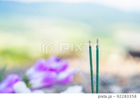 燃える線香と仏花 92283358