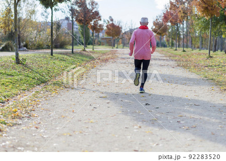 Rear View Of Senior Man Running Against Sky At Park Rear View Of Senior Man Running Against Sky At Park 92283520
