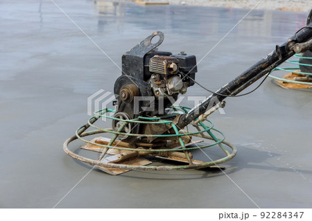 Workers are using concrete polishing machines for cement after pouring concrete on the foundation floor. 92284347