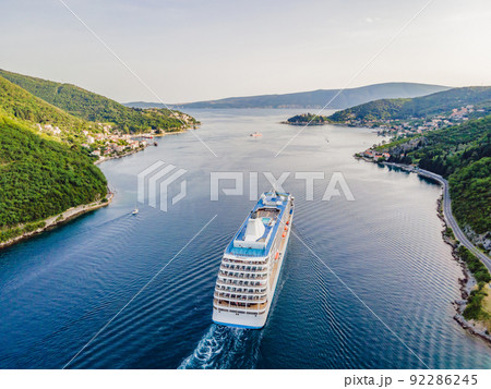 Luxury passenger liner in the bay of Kotor with travel returning after the Covid 19 pandemic Portrait of a disgruntled girl sitting at a cafe table 92286245