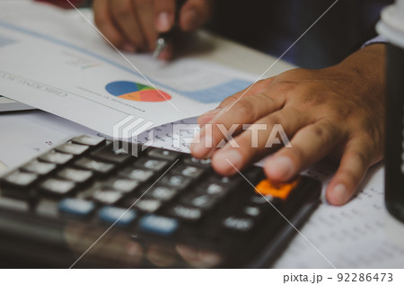 businessman holding calculators and business documents charts statistical data investment analysis and tax accounting. businessman holding calculators and business documents charts statistical data investment analysis and tax accounting. 92286473
