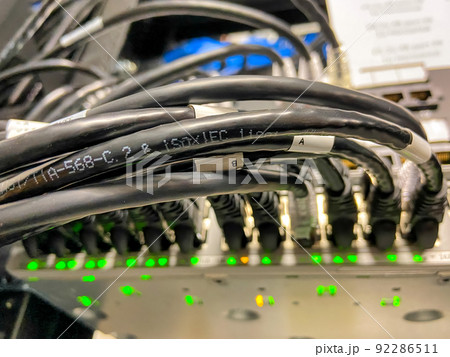 Ethernet cables connected to network equipment with green lights in data center Ethernet cables connected to network equipment with green lights in data center 92286511