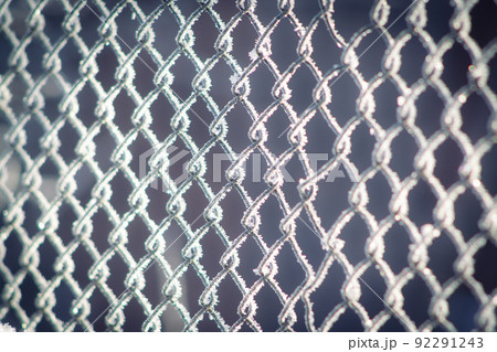 A metal wicker fence covered with ice crystals 92291243