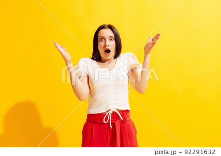 Studio shot of young beautiful woman in summer casual style outfit isolated on bright yellow background. Concept of beauty, art, fashion, human emotions 92291632