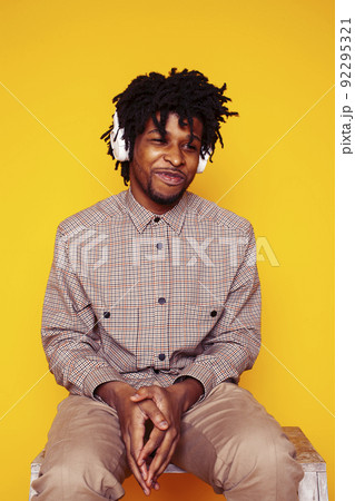 Young handsome african american guy student posing cheerful and gesturing on yellow background, lifestyle people concept close up Young handsome african american guy student posing cheerful and gesturing on yellow background, lifestyle people concept close up 92295321