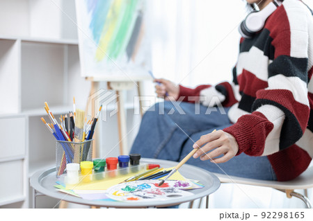 Female artist painting on canvas, Artist studio interior, Draw with watercolor, Drawing supplies , Painting and creativity, Use a brush to draw a pattern by stripes, Artwork, Using Paint Brush. Female artist painting on canvas, Artist studio interior, Draw with watercolor, Drawing supplies , Painting and creativity, Use a brush to draw a pattern by stripes, Artwork, Using Paint Brush. 92298165