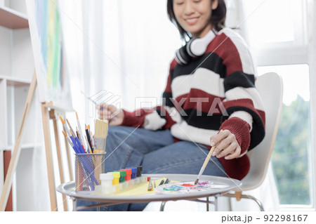 Female artist painting on canvas, Artist studio interior, Draw with watercolor, Drawing supplies , Painting and creativity, Use a brush to draw a pattern by stripes, Artwork, Using Paint Brush. Female artist painting on canvas, Artist studio interior, Draw with watercolor, Drawing supplies , Painting and creativity, Use a brush to draw a pattern by stripes, Artwork, Using Paint Brush. 92298167