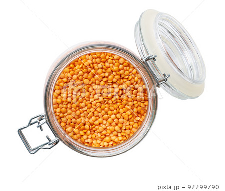Heap of uncooked dry red lentils in glass storage jar isolated on white background top view. 92299790