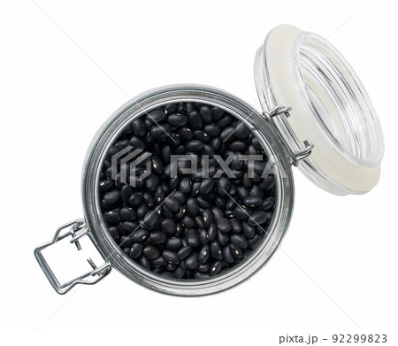 Heap of uncooked dry black beans grains in glass storage jar isolated on white background top view. 92299823