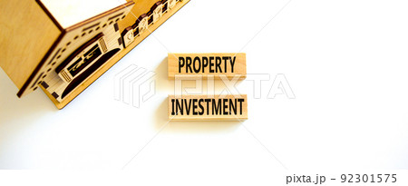 Property investment symbol. Concept words Property investment on wooden blocks on a beautiful white table white background. Wooden house model. Business Property investment concept. Copy space. 92301575