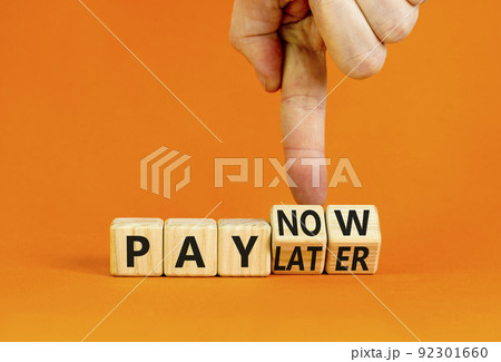 Pay later or now symbol. Businessman turns wooden cubes and changes concept words Pay later to Pay now. Beautiful orange table orange background. Business pay later or now concept. Copy space. Pay later or now symbol. Businessman turns wooden cubes and changes concept words Pay later to Pay now. Beautiful orange table orange background. Business pay later or now concept. Copy space. 92301660
