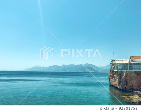 clear, blue water of the sea. a yacht with tourists floats on the water. next to the sea are high mountains. rest in a hot country by the water. swimming in the sea 92301753