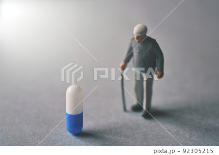 薬とミニチュアのシニア男性 92305215