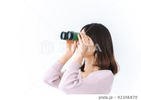 双眼鏡で遠くを見る若い女性 92306870