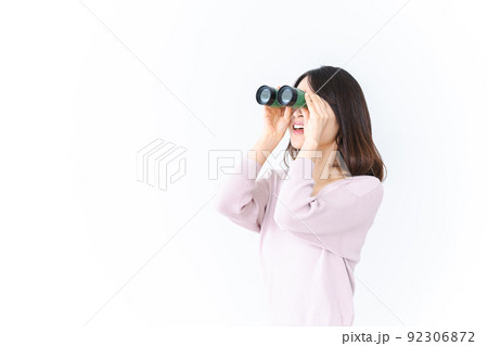 双眼鏡で遠くを見る若い女性 92306872