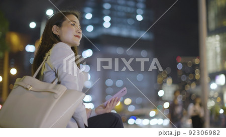 仕事終わりにスマホを見るビジネスウーマン 女性 スマートフォン 仕事終わりにスマホを見るビジネスウーマン 女性 スマートフォン 92306982