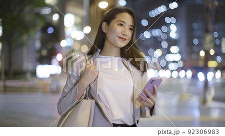 会社帰りにスマホを見るビジネスウーマン 女性 スマートフォン 92306983