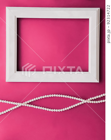 White horizontal art frame and pearl jewellery on pink background as flatlay design, artwork print or photo album concept White horizontal art frame and pearl jewellery on pink background as flatlay design, artwork print or photo album concept 92314722