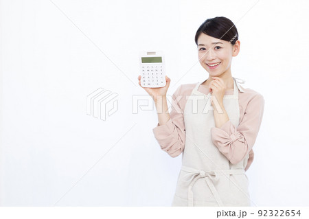 電卓を持って笑顔で考えている30代の主婦 電卓を持って笑顔で考えている30代の主婦 92322654