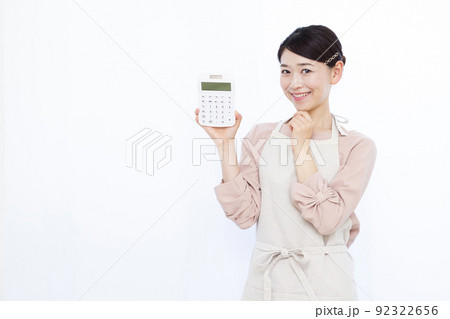 電卓を持って笑顔で考えている30代の主婦 電卓を持って笑顔で考えている30代の主婦 92322656