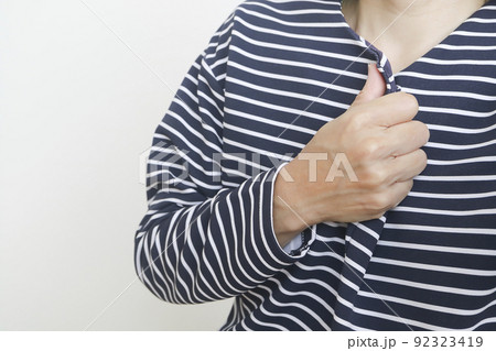 胸元で手を握る女性 92323419