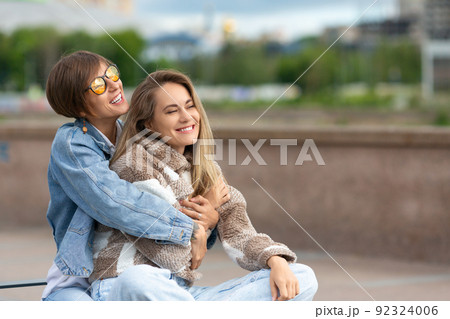 Love and relationships concept - lesbian couple during outdoor walking. 92324006