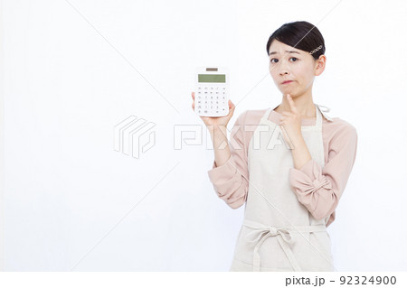 電卓を持ち悩んでいる30代の主婦 92324900
