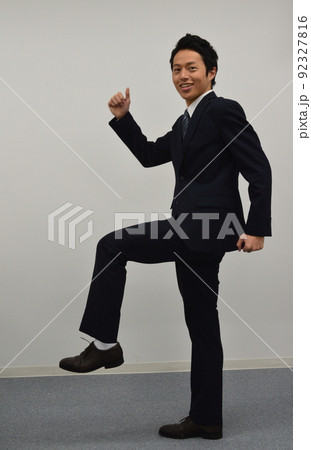 片足を上げてグーサインをする若い男性 片足を上げてグーサインをする若い男性 92327816