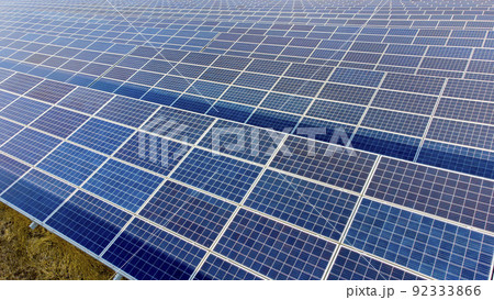 Aerial drone view flight over solar power station panels. Aerial top view of solar farm. Green energy, electrical innovation. Renewable Energy. Industrial Solar Energy Farm producing solar power. Aerial drone view flight over solar power station panels. Aerial top view of solar farm. Green energy, electrical innovation. Renewable Energy. Industrial Solar Energy Farm producing solar power. 92333866