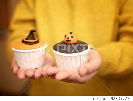 Halloween muffins with decorations in the form of ghosts, pumpkins and witch hats. A set of festive cupcakes and treats for a Halloween party 92335228