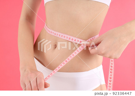 Concept of weight loss with young slim woman on pink background Concept of weight loss with young slim woman on pink background 92336447