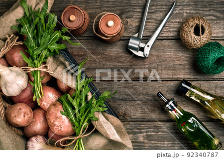 Fresh potatoes, oil, garlic and spicy herbs on a kitchen wooden background. 92340787