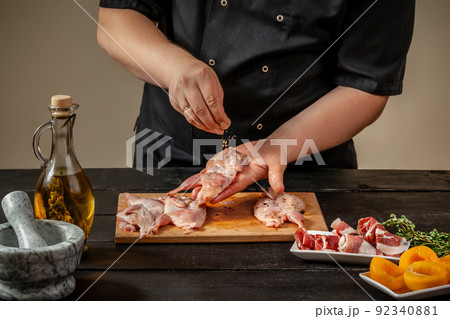 The chef prepares raw quail carcasses in the kitchen. Fresh raw meat quails ready for cooking on the wooden board The chef prepares raw quail carcasses in the kitchen. Fresh raw meat quails ready for cooking on the wooden board 92340881