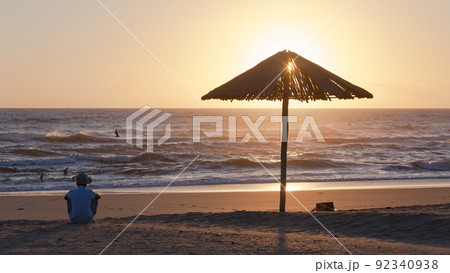 Beach Ocean Sunrise Man Sitting Umbrella Silhouetted 92340938