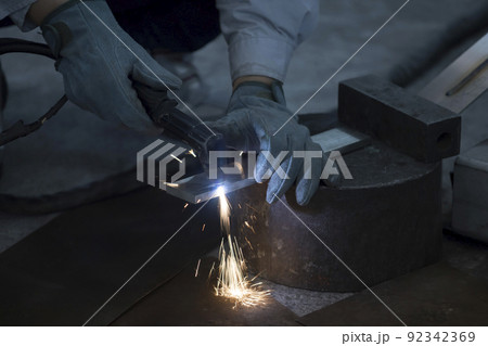 プラズマ切断機で金属を切断する男性手元 92342369