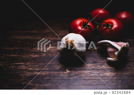 Garlic bulbs with vine tomatoes on wooden vintage background. Close Up Garlic bulbs with vine tomatoes on wooden vintage background. Close Up 92342884