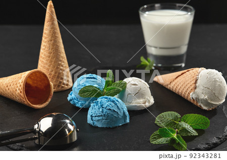 Close-up shot of a creamy and blueberry ice cream served on a dark slate, black background. 92343281