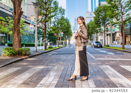 東京丸の内　横断歩道を渡る笑顔の若い女性 92344563